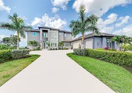 A large contemporary home surrounded by palm trees in Southwest Florida
